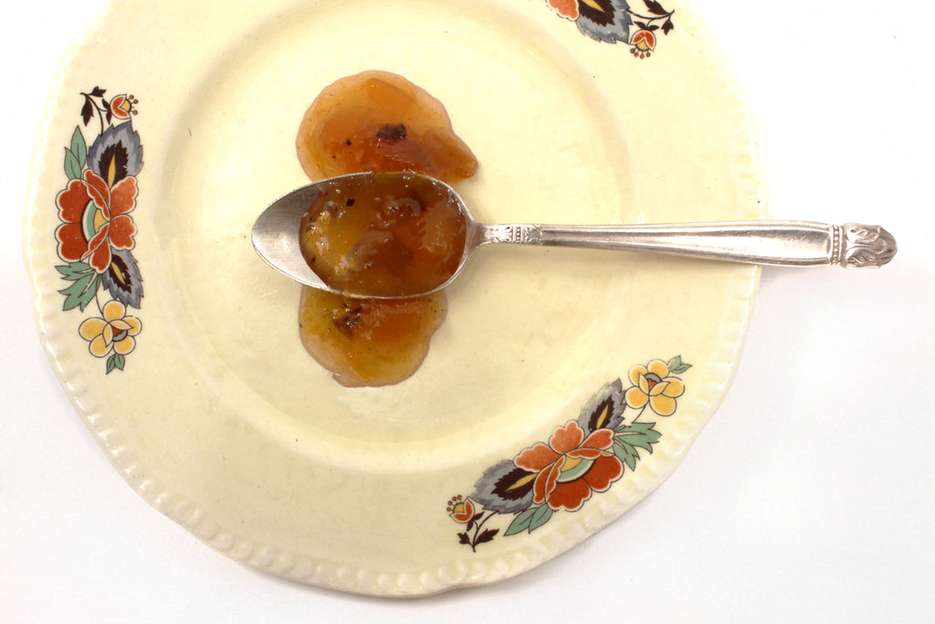 Deliciousness Preserves Pueblo Chile Peach displayed on spoon, rich texture with bits of peach and roasted Pueblo Colorado chiles