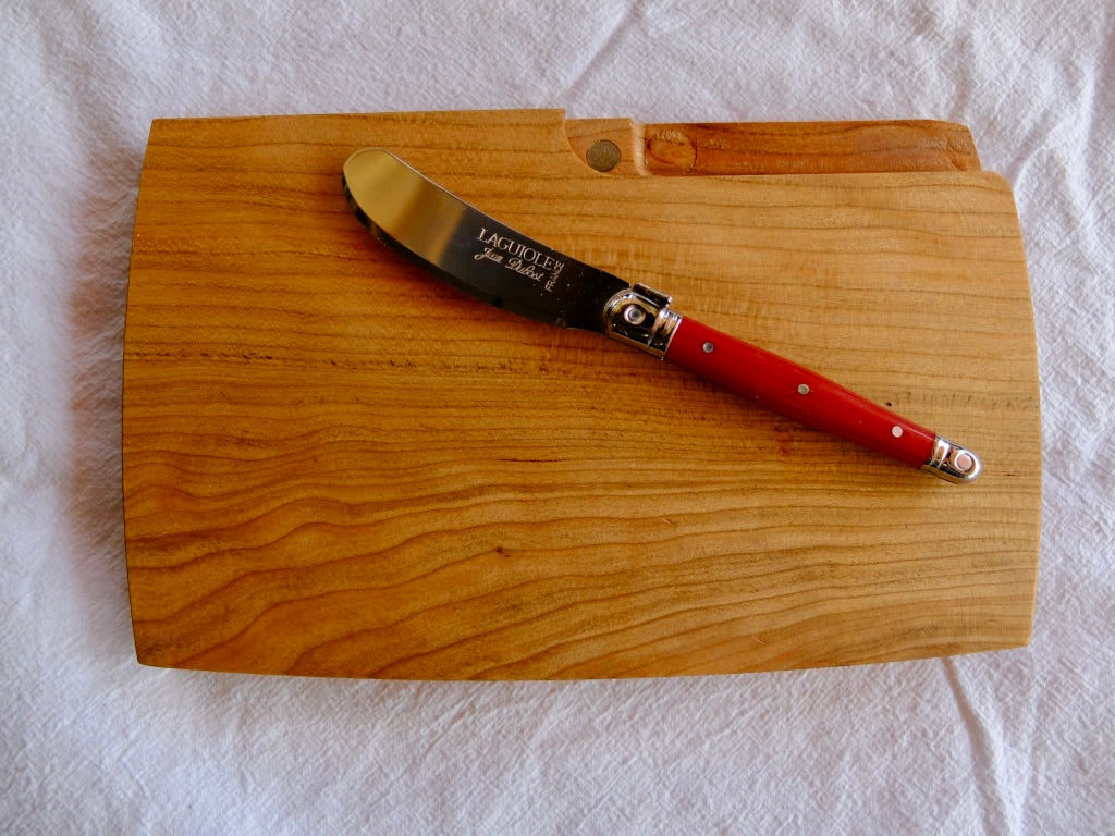 Hand Carved Cherry Wood portable cutting board/cheeseboard with magnetized knife compartment holding a Laguiole Red Cheese Knife
