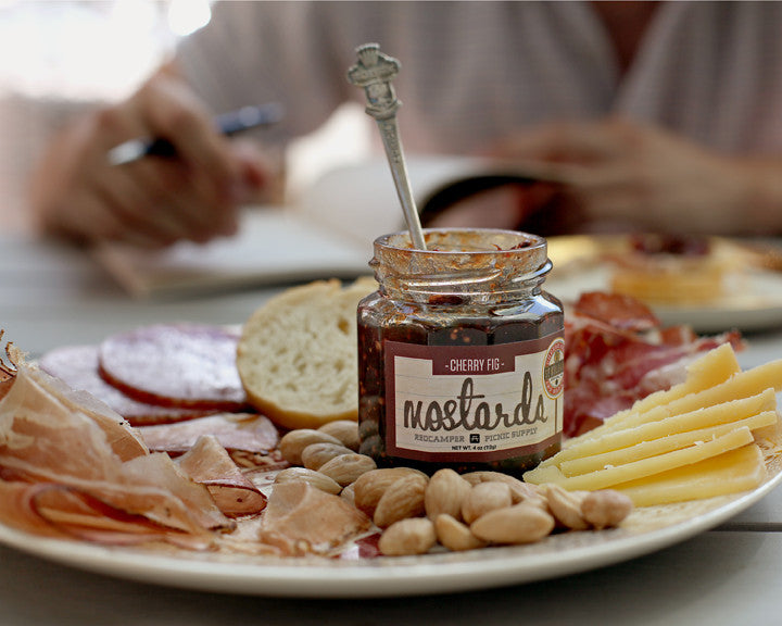 Jar RedCamper Cherry Fig Mostarda on charcuterie board with cured meats, cheeses bread and nuts Picnic Supply