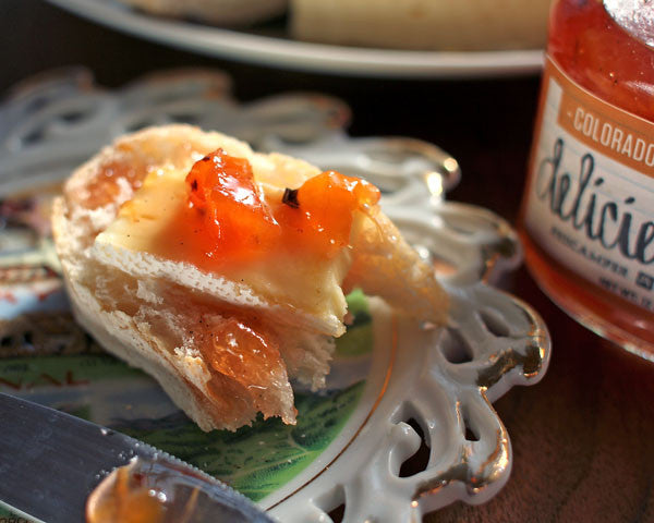 Deliciousness Jam Colorado Whiskey Peach Preserves poured over bire cheese and sourdough bread summertime in a jar 
