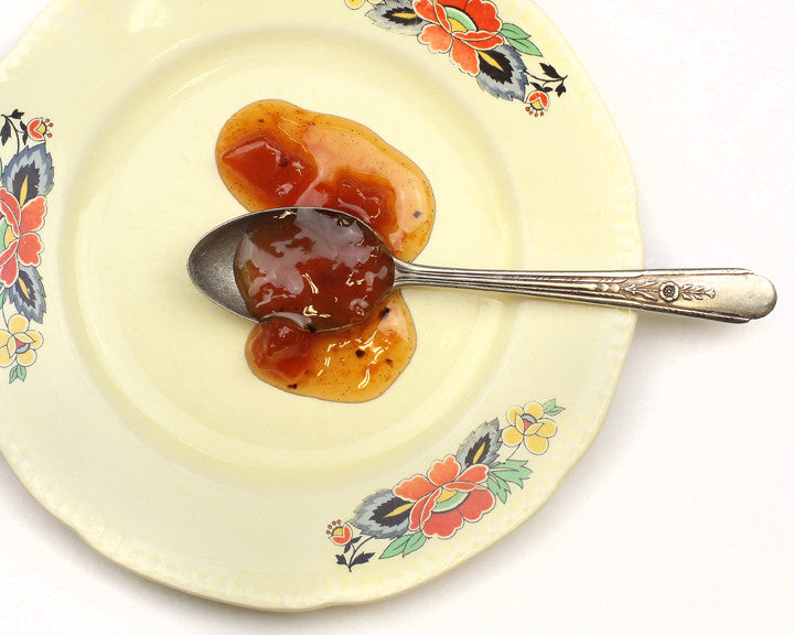 Colorado Whiskey Peach Preserves displayed on retro spoon, saucy texture with peach chunks and Madagascar vanilla flecks 